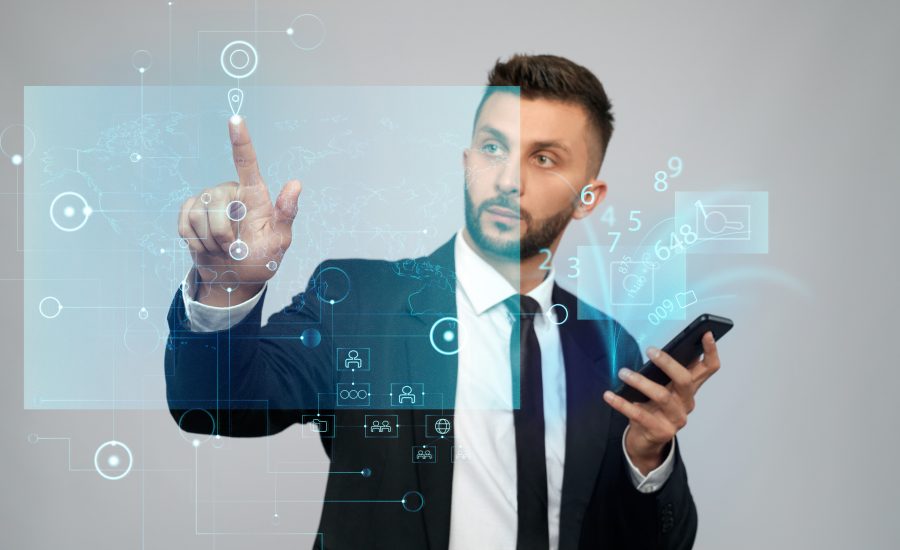 Front view of businessman in suit holding phone with virtual projection in office. Serious bearded man clicking virtual button on digital tactile charts screen. Concept of gadgets, digitalization.