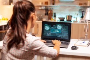 Hacker woman launching a cyberattack on bank firewall from home during night time. Programmer writing a dangerous malware for cyber attacks using performance laptop during midnight.